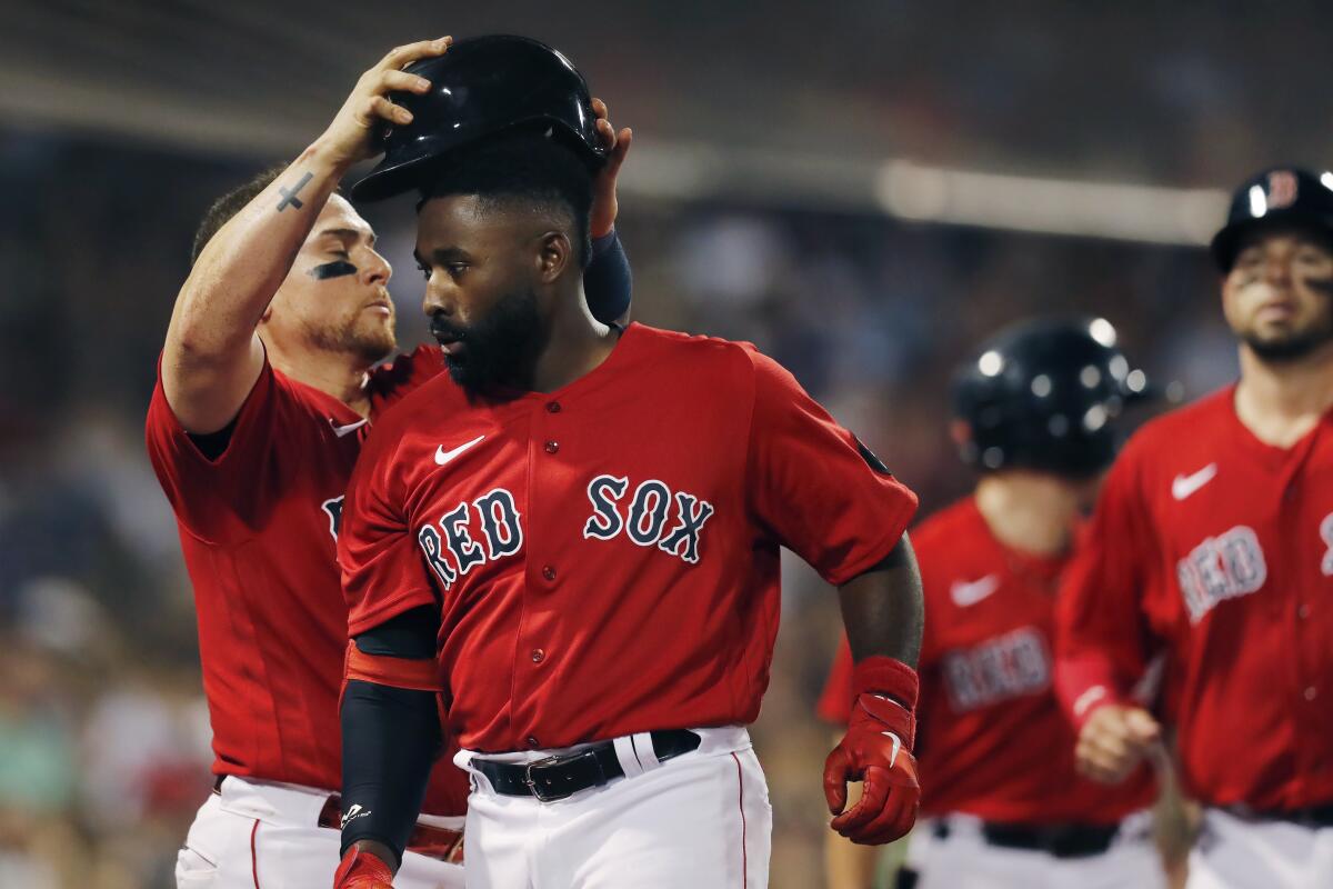 Boston Red Sox's Jackie Bradley Jr., center, celebrates his two-run home run with Christian Vazquez, left, during the fourth inning of the team's baseball game against the Toronto Blue Jays, Friday, July 22, 2022, in Boston. (AP Photo/Michael Dwyer)