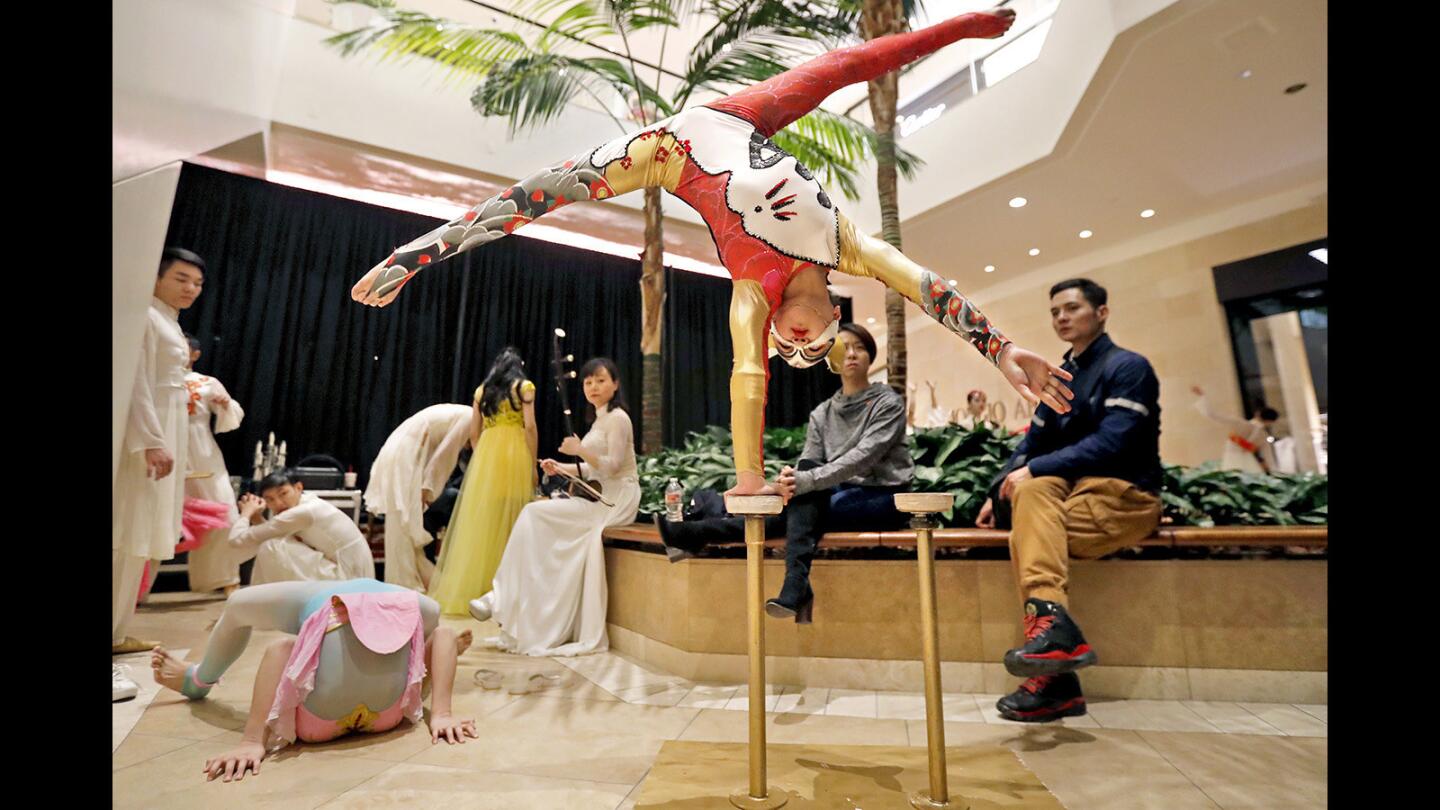Fu Xing, 11, warms up behind the stage with other members of the Hunan Provincial Song and Dance Theatre during South Coast Plaza's Lunar New Year celebration Tuesday night in Costa Mesa.