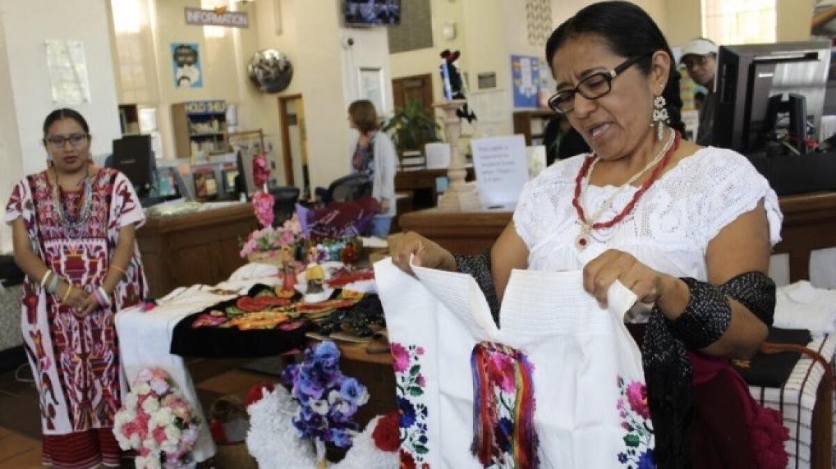 Chelín Molina muestra una prenda de Oaxaca y explica su uso en la danza.