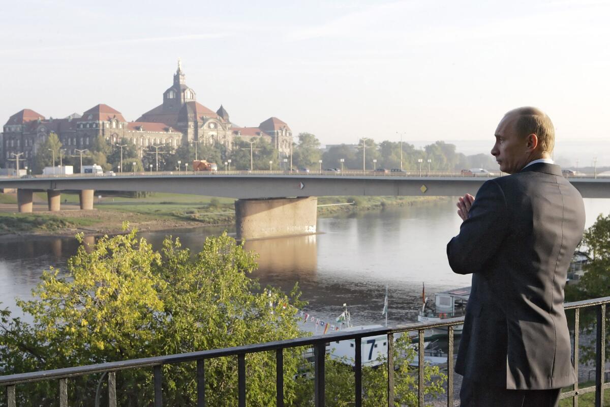 Russian President Vladimir Putin stands on the embankment of the Elbe River 