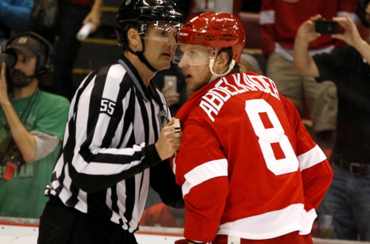 Red Wings left wing Justin Abdelkader is escorted off the ice by a referee after he dropped Ducks defenseman Toni Lydman (not pictured) with an illegal hit on Friday night in Detroit.