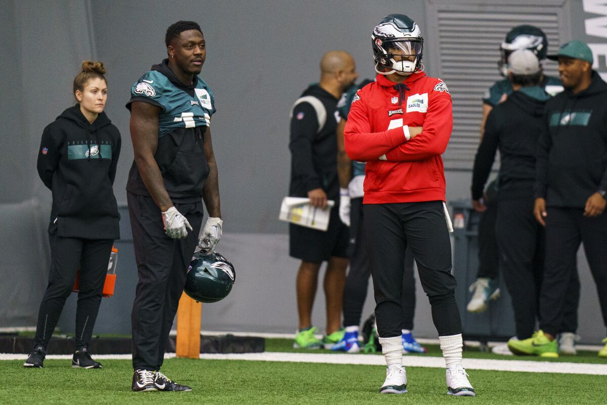 Philadelphia Eagles quarterback Jalen Hurts, right, and wide receiver A.J. Brown (11), left, watches as they wait for their next drill during an NFL football workout, Thursday, Jan. 26, 2023, in Philadelphia. The Eagles are scheduled to play the San Francisco 49ers Sunday in the NFC championship game.(AP Photo/Chris Szagola)