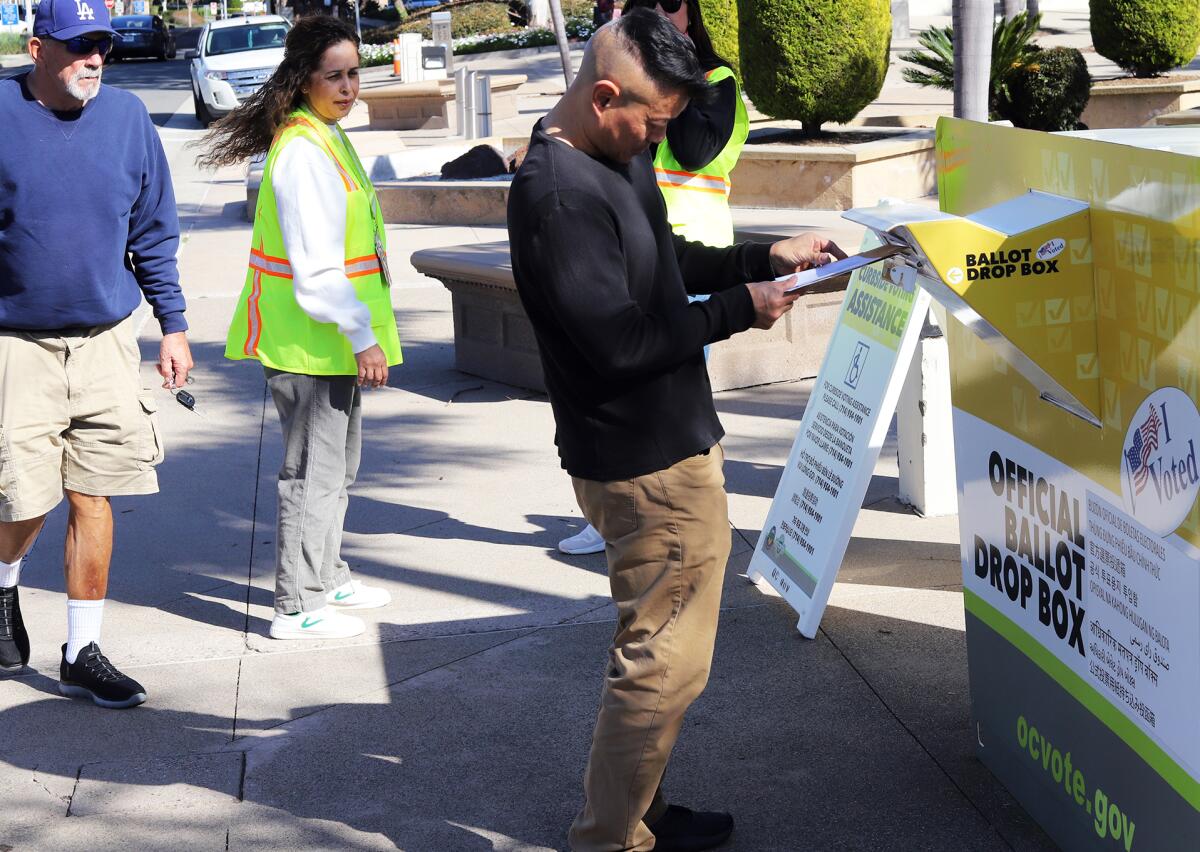 A voter drops his ballot into the official ballot drop box on Super Tuesday outside Huntington Beach City Hall.