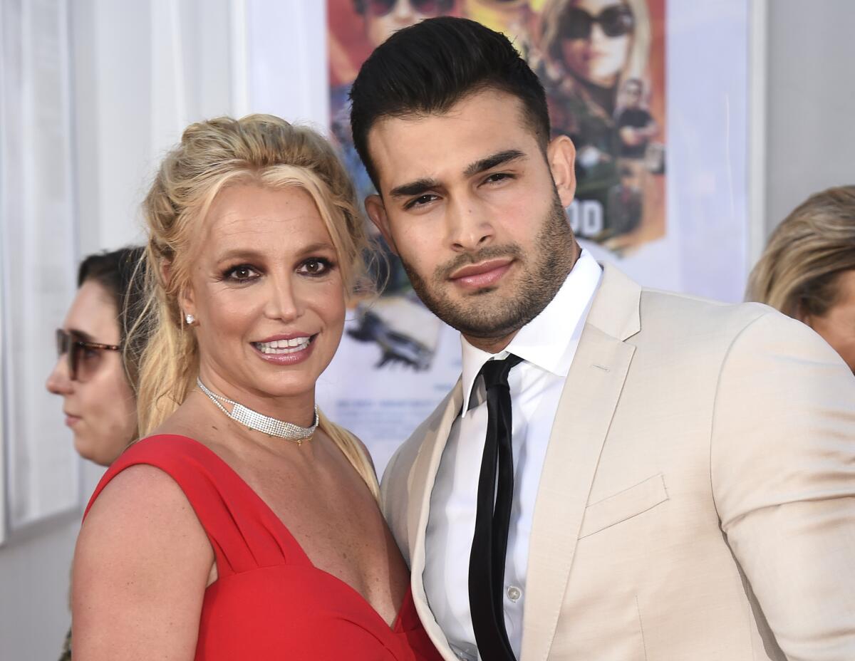 Britney Spears and Sam Asghari pose together for cameras at a red-carpet event