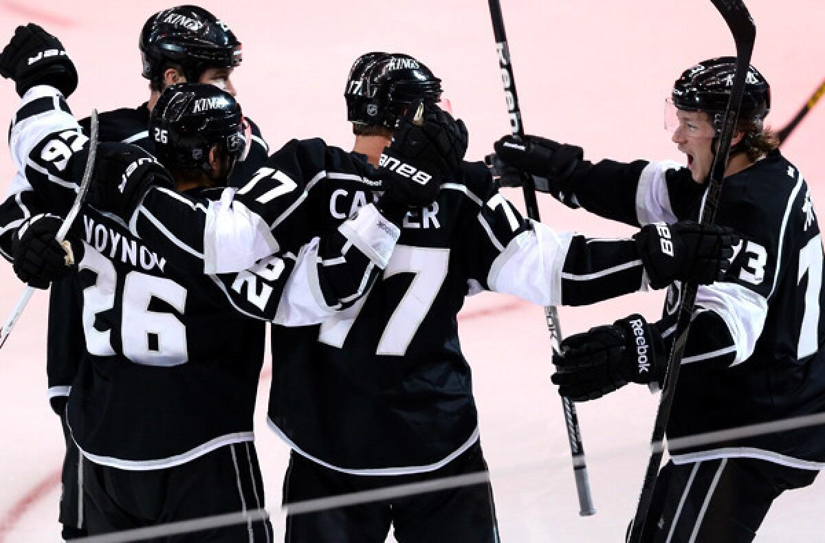 Kings teammates Dustin Penner, left, Slava Voynov, Jeff Carter and Tyler Toffoli celebrate after Voynov scored against the Blackhawks in the second period of Game 3 on Tuesday night.