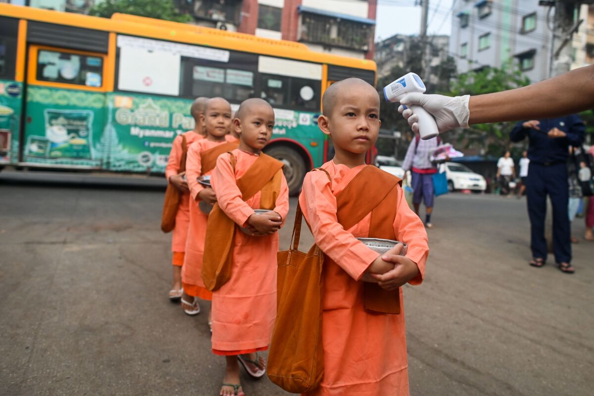 Young Buddhist nuns line up to have their temperature taken by authorities in Yangon, Myanmar.