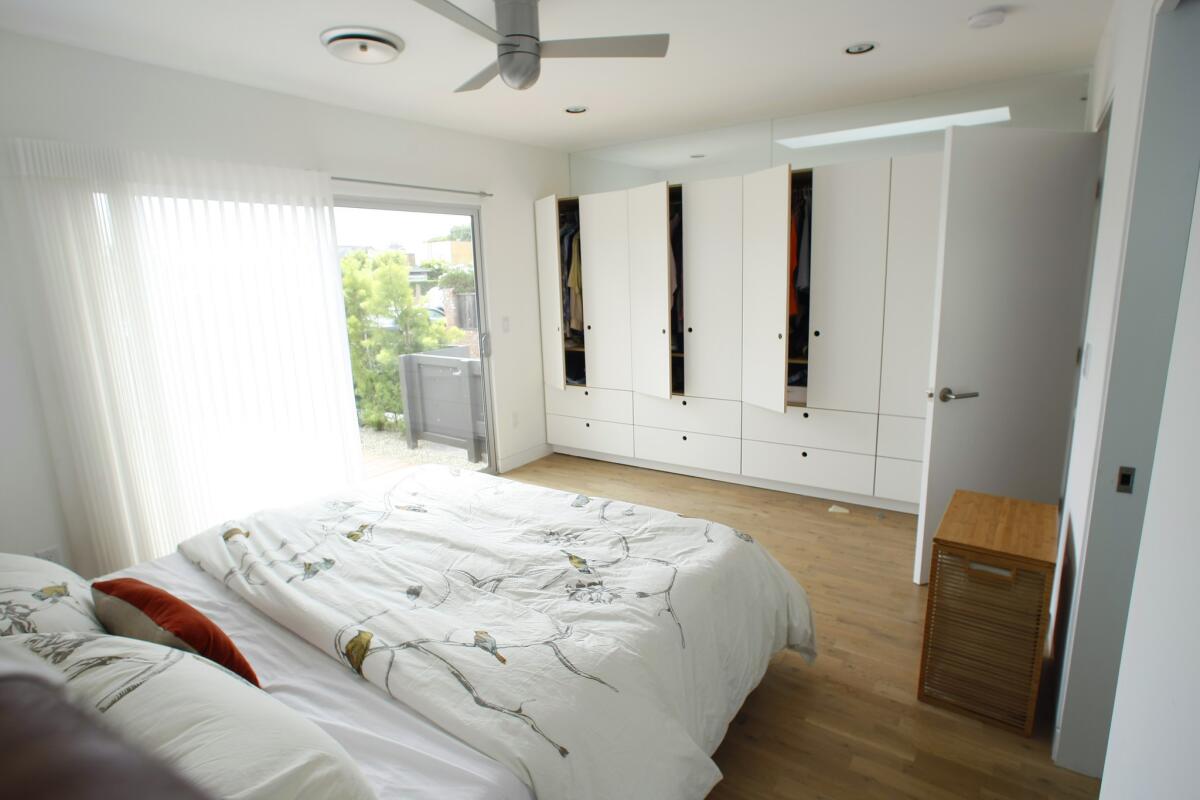 More custom cabinetry in the master bedroom, where wardrobes with deep drawers replaced a traditional closet. Sweet simply drilled holes in the wood for pulls.