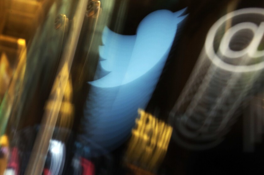 The Twitter logo appears on a phone at the New York Stock Exchange.