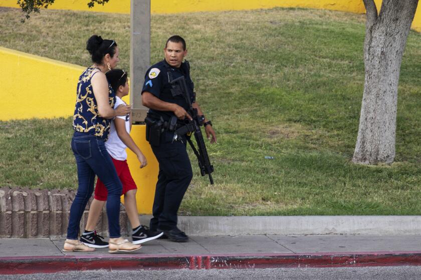 An Odessa police officer escort bystanders away from an area investigated for a shooting in Odessa, Texas, Saturday, Aug. 31, 2019, following a deadly shooting. Several people were dead after a gunman who hijacked a postal service vehicle in West Texas shot more than 20 people, authorities said Saturday. The gunman was killed and a few law enforcement officers were among the injured. (Jacy Lewis/Reporter-Telegram via AP)