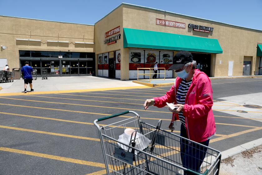 ROWLAND HEIGHTS, CA - JULY 11: A woman gathers her groceries in the parking of the 1000 block of North Nogales Avenue near the 99 Ranch market on Monday, July 11, 2022 in Rowland Heights, CA. A couple was pistol-whipped and robbed in a parking lot in a parking lot in the 1000 block of North Nogales Avenue near the 99 Ranch market in broad daylight, according to the Los Angeles County Sheriff's Department. Authorities said the two suspects pistol-whipped the victims on their heads and robbed one of the victims of a $60,000 Rolex. (Gary Coronado / Los Angeles Times)