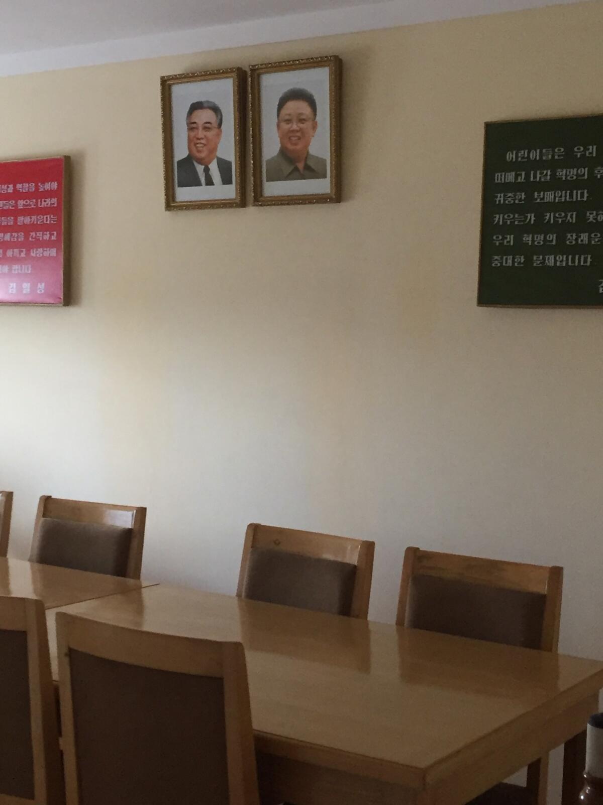 Portraits of Kim Il Sung and Kim Jong Il hang on the wall at the Changchon nursery school. (Julie Makinen / Los Angeles Times)