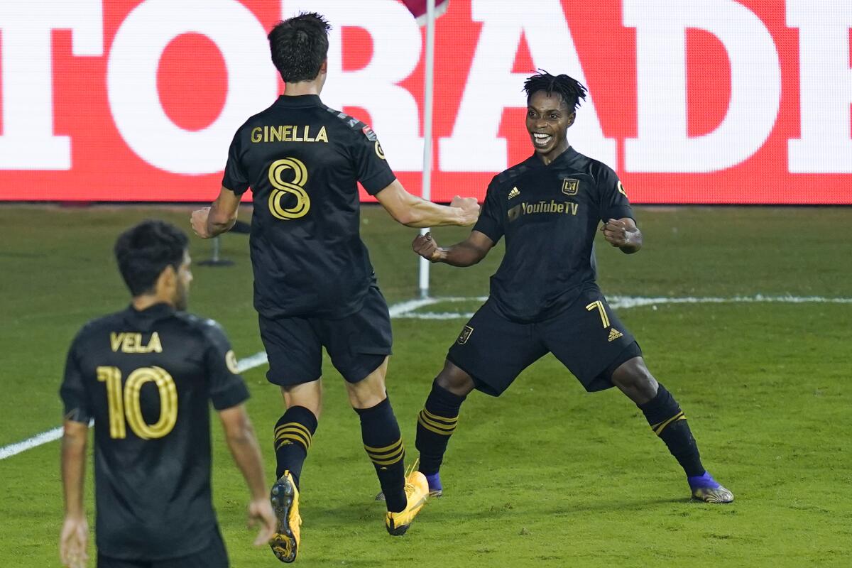 LAFC forward Latif Blessing celebrates with teammates Francisco Ginella and Carlos Vela.