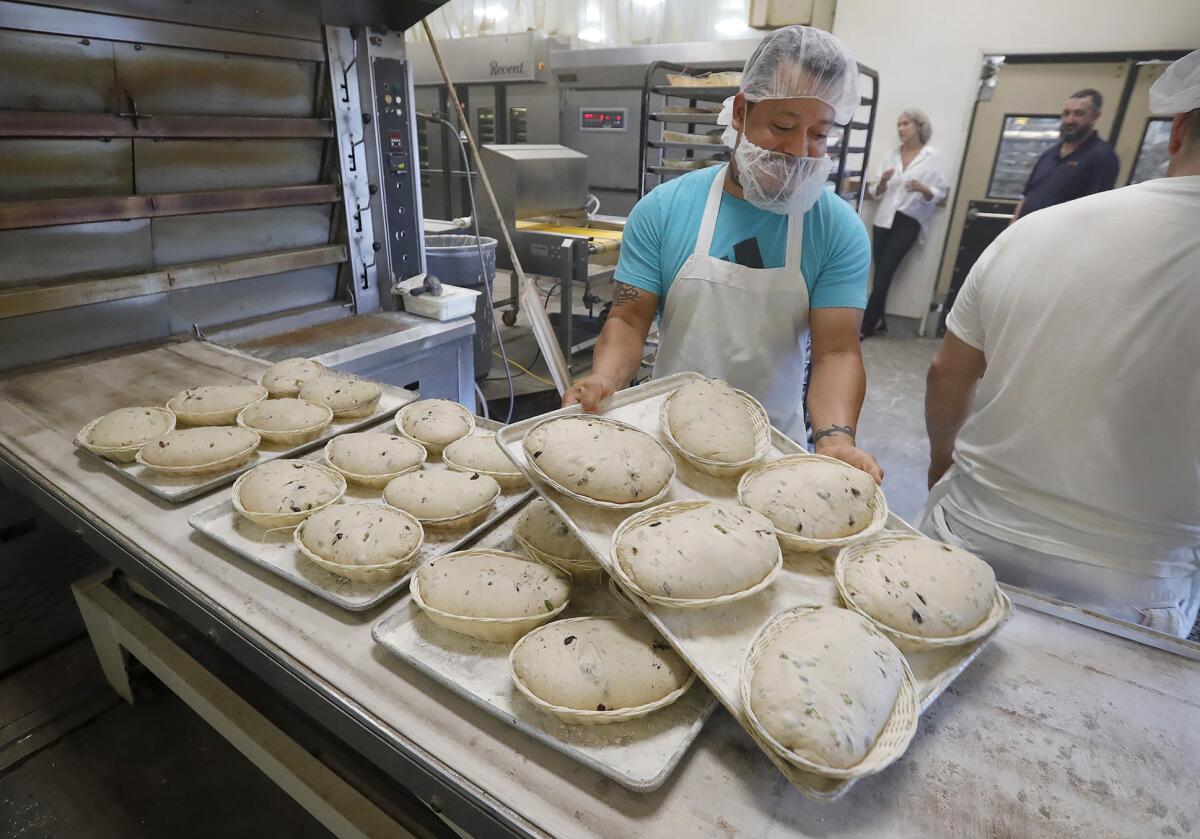 Baker Jorge Sanchez prepares baskets of dough at Bread Artisan Bakery in Santa Ana.