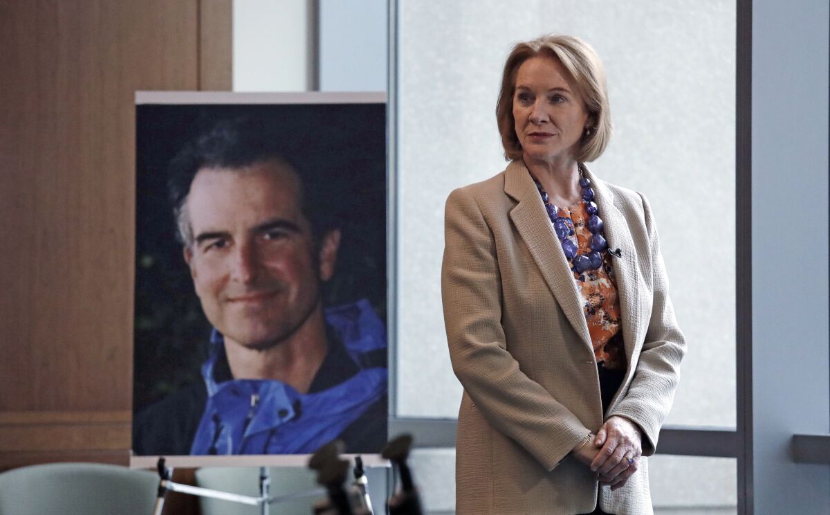 FILE - In this Feb. 21, 2018, file photo, Seattle Mayor Jenny Durkan, former U.S. Attorney for the Western District of Washington, stands near a photo of slain Assistant United States Attorney Thomas Wales in Seattle. Rewards totaling $2.5 million are now being offered for information that helps solve the killing of Wales in Seattle 20 years ago. (AP Photo/Elaine Thompson, File)