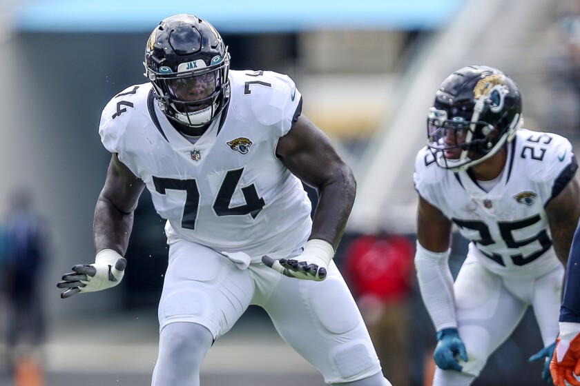 FILE- Jacksonville Jaguars offensive tackle Cam Robinson (74) during an NFL football game against the Denver Broncos, on Sept. 19, 2021, in Jacksonville, Fla. Robinson signed his franchise tender with the Jaguars on Wednesday, April 13. 2022, guaranteeing him $16.7 million this season. (AP Photo/Gary McCullough, File)