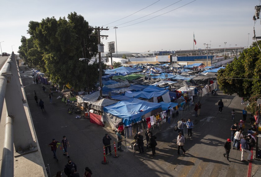 Migrants and asylum seekers go about their lives in a migrant camp near the port of entry at Tijuana's Chaparral plaza