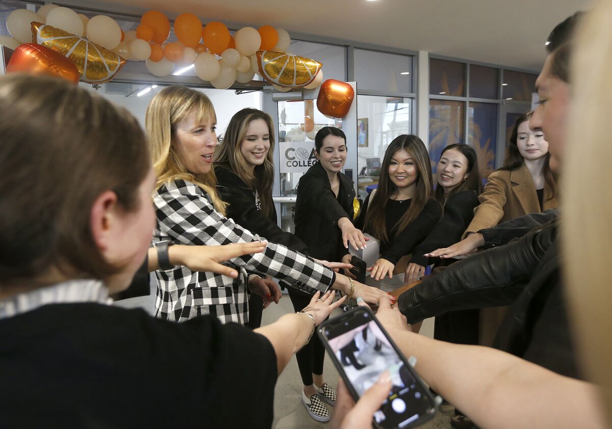 OCC fashion instructor Michelle Craner, second from left, shares a group high-five with students Wednesday.