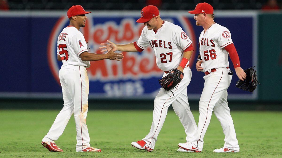 Angels' Ben Revere (25), Mike Trout (27) and Kole Calhoun (56) celebrate defeating the Philadelphia Phillies at Angel Stadium on Thursday.