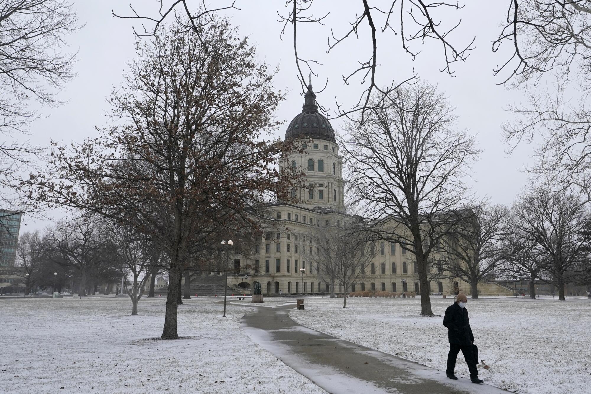 A person walks across the Statehouse grounds in Topeka, Kan. 