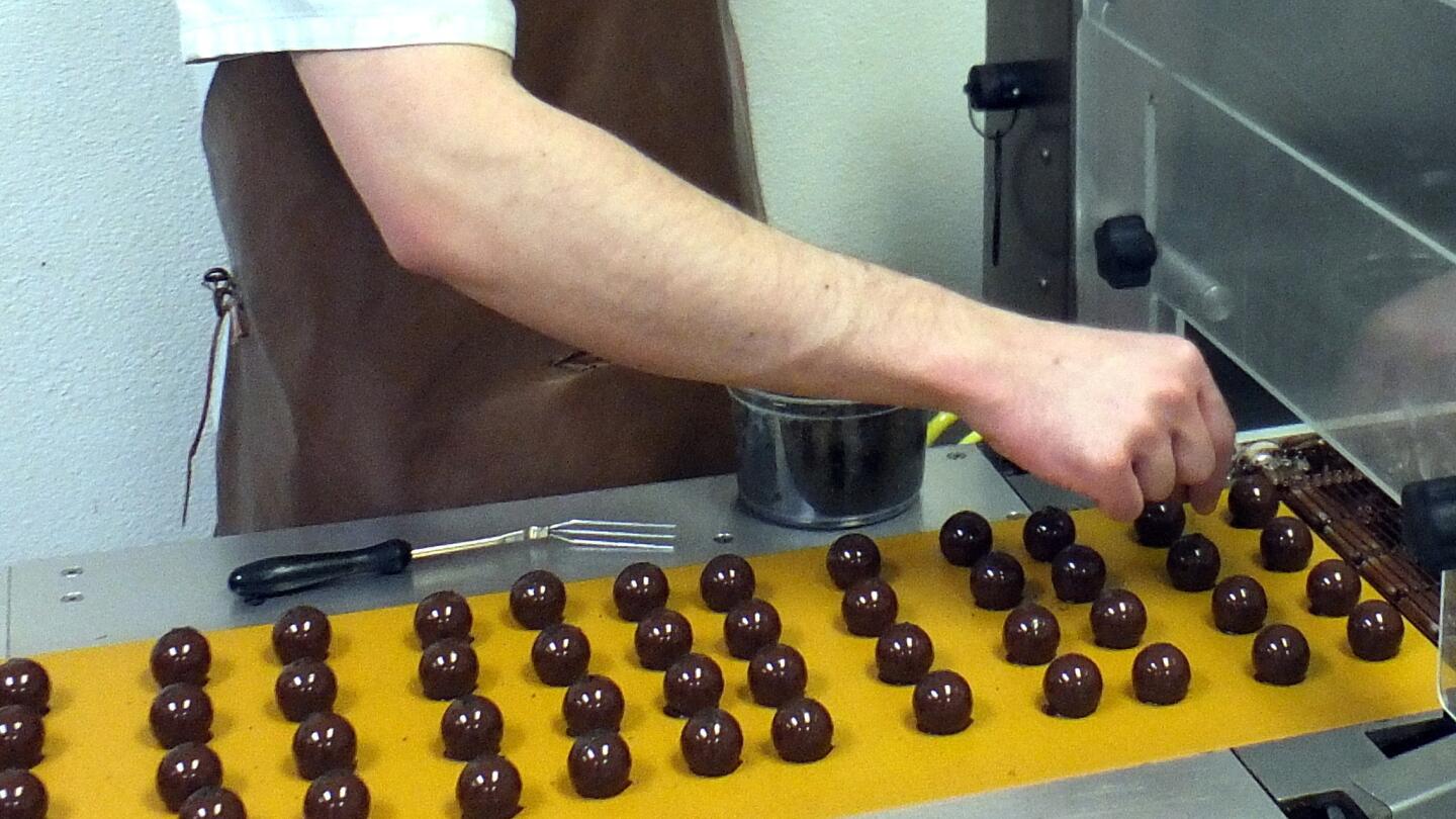 Bits of Earl Grey tea are sprinkled atop just-made chocolates at Jean-Marie Auboine Chocolatier, a Las Vegas company run by a master chocolate maker from France.
