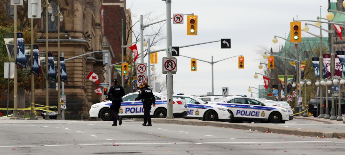 Ottawa police officers stand guard near the National War Memorial where a soldier was shot earlier in the day Wednesday.