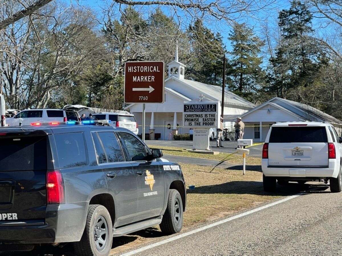 Sheriff's deputies stand nearby as their vehicles are parked outside Starrville Methodist Church near Winona, Texas.