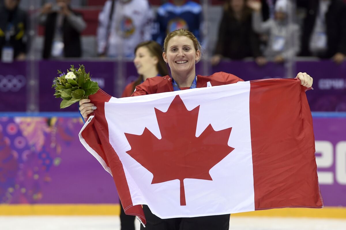 Canada's Hayley Wickenheiser celebrates with the Canadian flag.
