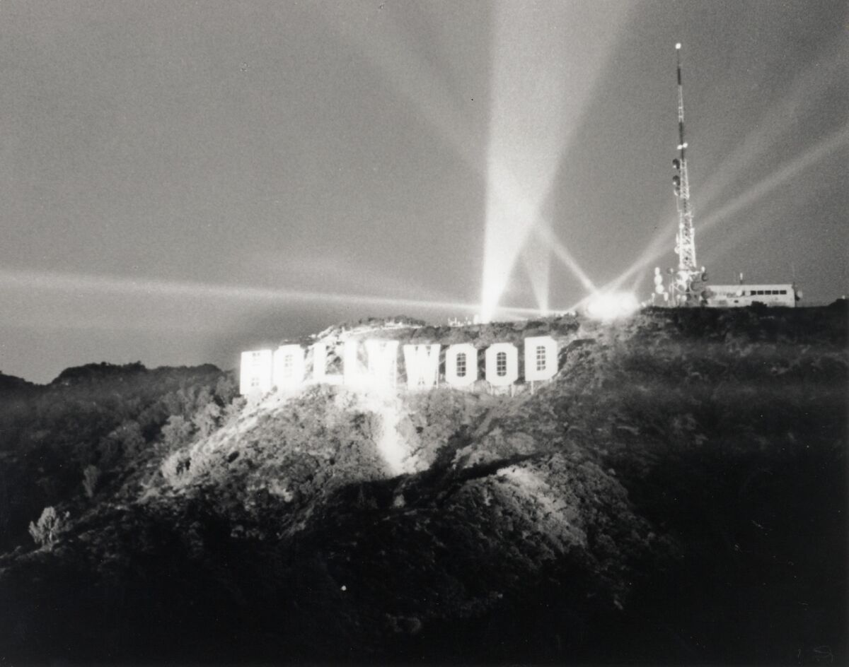 A historical photo of the Hollywood sign lighted at night. 