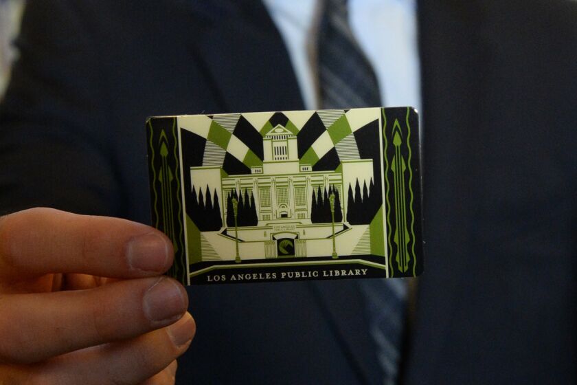 Mayor Eric Garcetti holds L.A.’s first artist-designed, limited-edition library card.