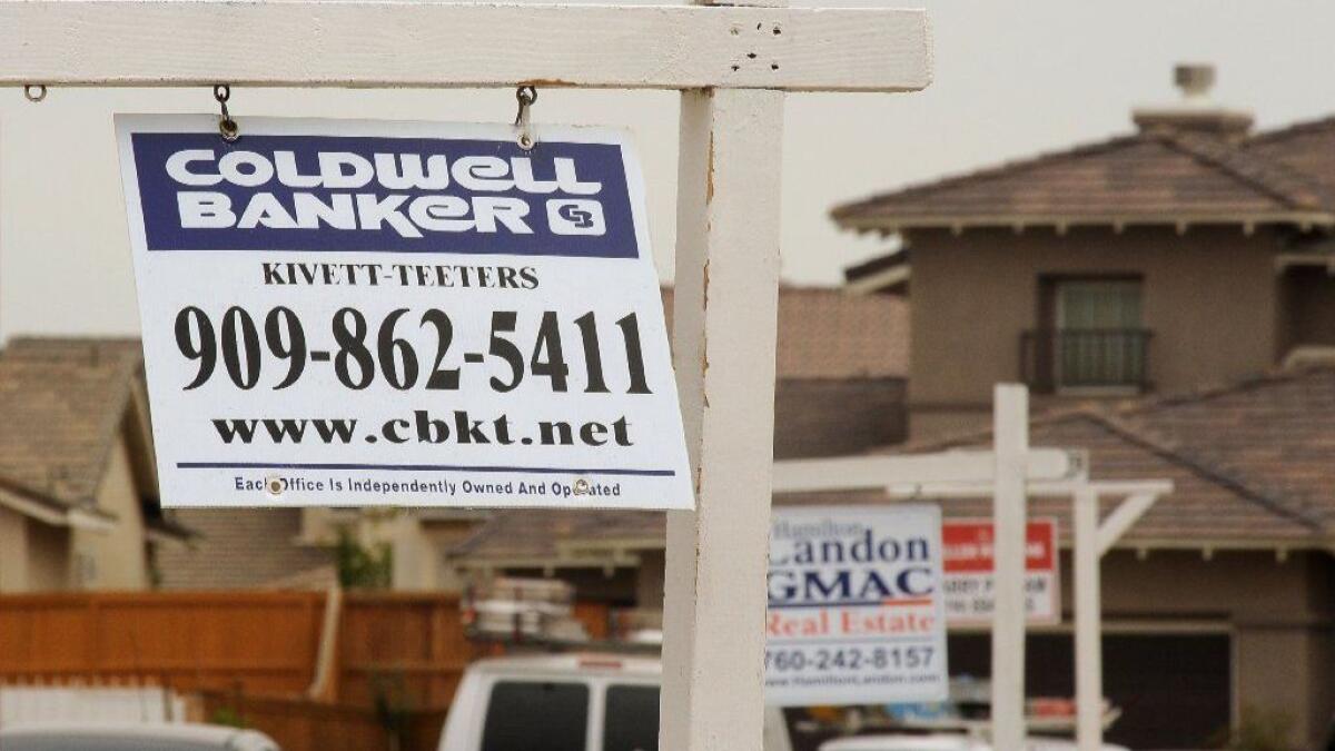 For-sale signs line a residential street in Adelanto in 2009.