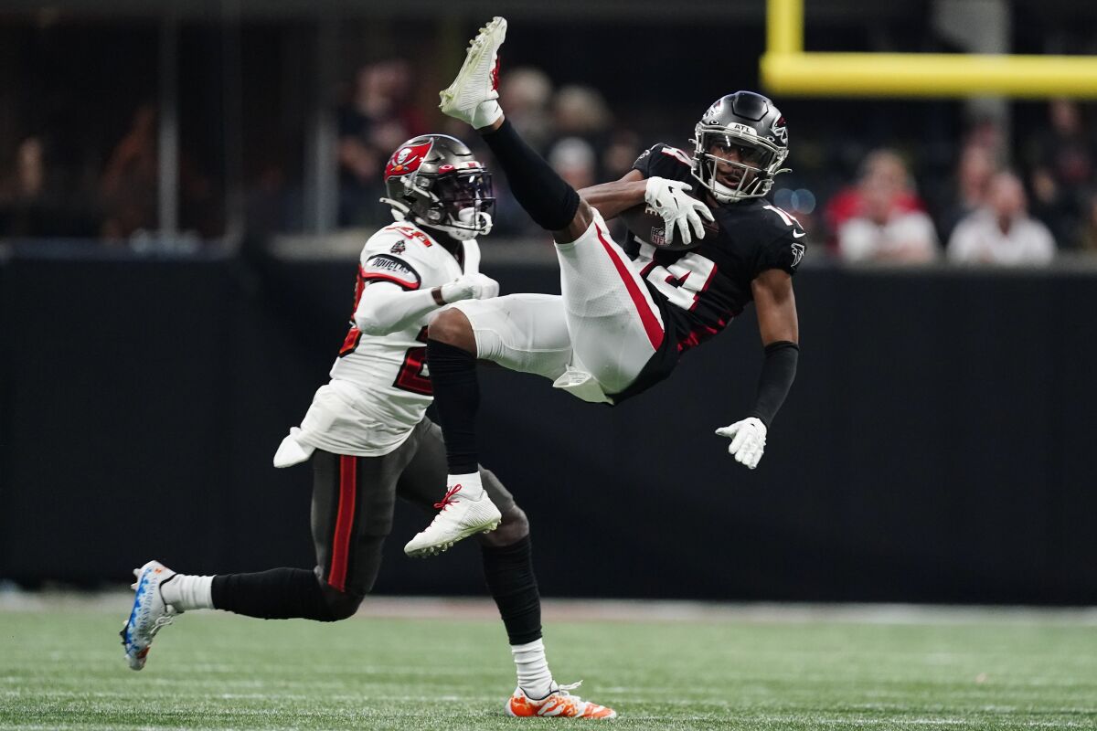 Atlanta Falcons wide receiver Russell Gage (14) makes a leaping catch against Tampa Bay Buccaneers cornerback Rashard Robinson (28) during the second half of an NFL football game, Sunday, Dec. 5, 2021, in Atlanta. (AP Photo/John Bazemore)