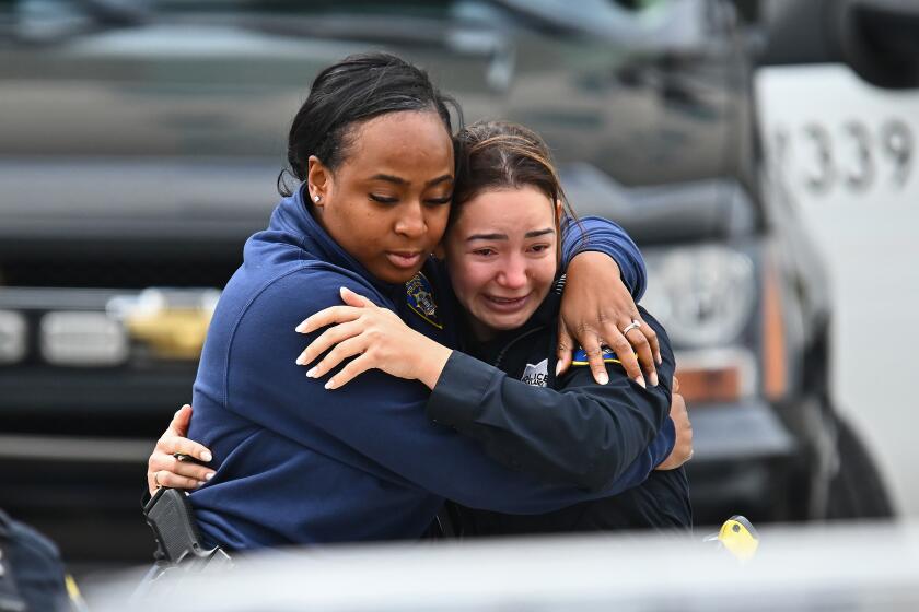 Oakland Police officers console each other as they leave Highland Hospital in Oakland, Calif., on Friday, Dec. 29, 2023. 