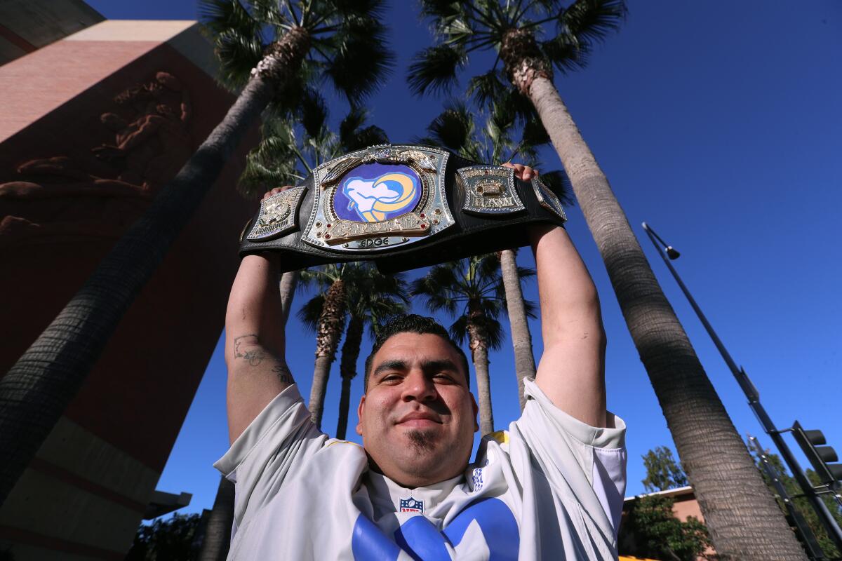 Delino Garcia of Azusa holds up a Rams' victory belt along the parade route.