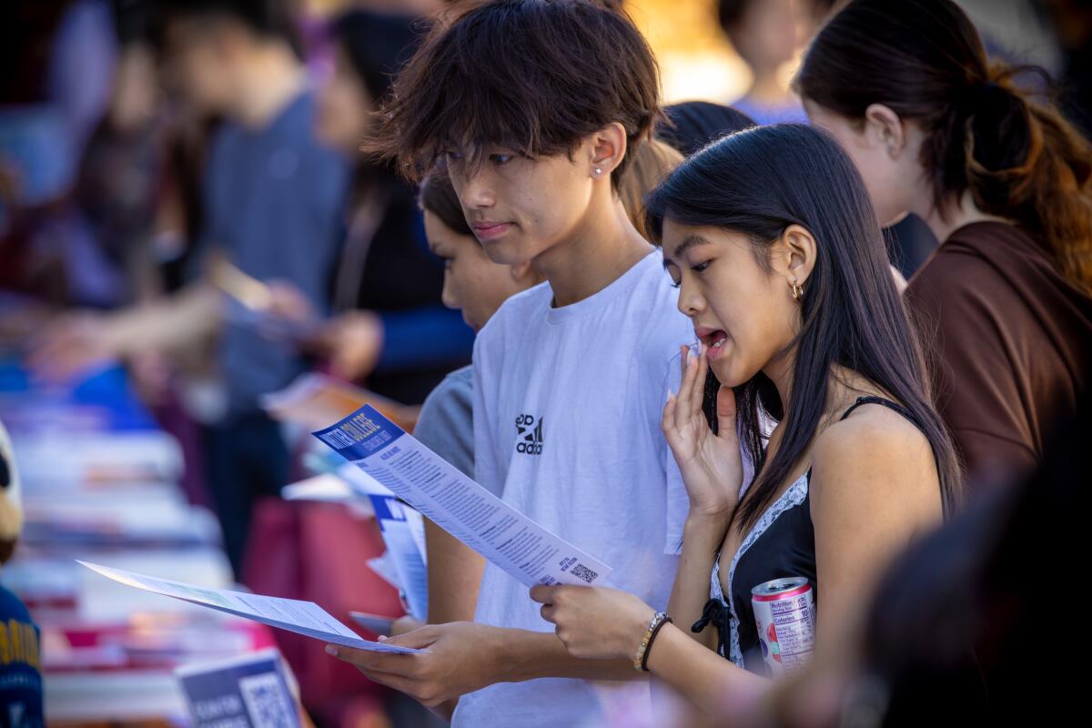 \Ethan Chen, 17, left, & Audrey Balthazar, 16, Arcadia High students, browse through material at annual college & career fair
