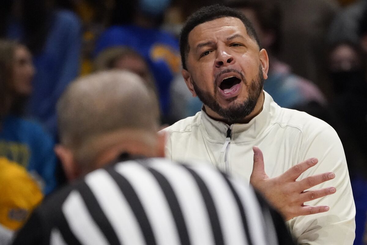 Pittsburgh head coach Jeff Capel, right, talks to an official during the first half of an NCAA college basketball game against Louisville, Saturday, Jan. 15, 2022, in Pittsburgh. (AP Photo/Keith Srakocic)