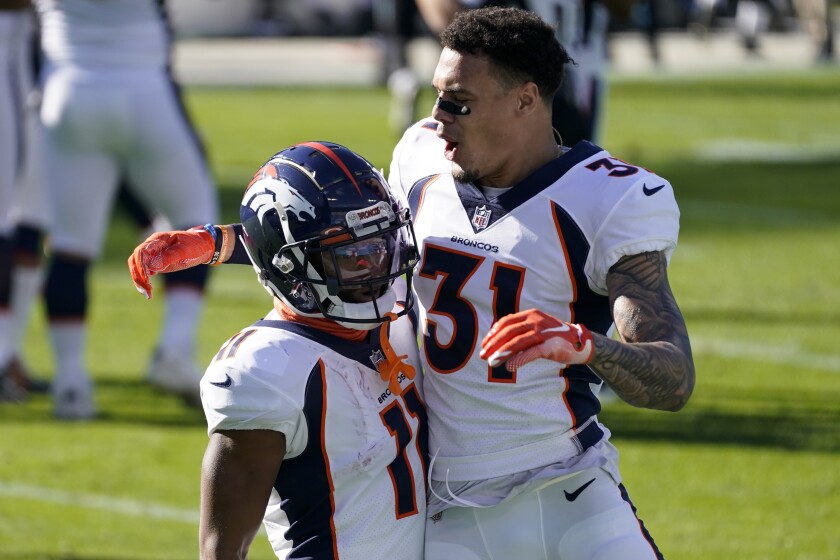 Denver Broncos wide receiver Diontae Spencer, left, celebrates after scoring with safety Justin Simmons during the first half of an NFL football game against the Carolina Panthers Sunday, Dec. 13, 2020, in Charlotte, N.C. (AP Photo/Gerry Broome)