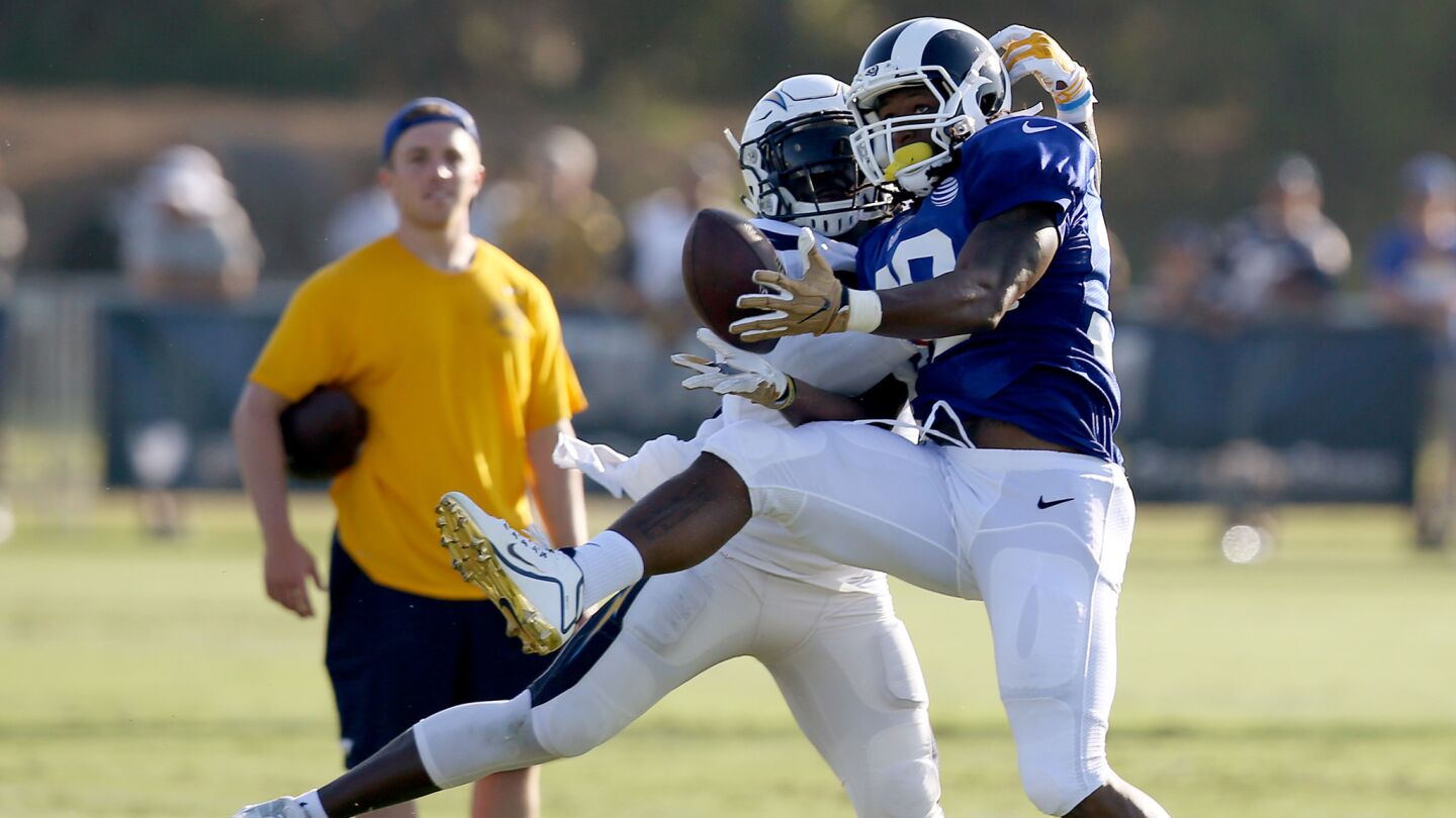 Chargers linebacker Jatavis Brown and Rams running back Todd Gurley II fight for possession of a pass.