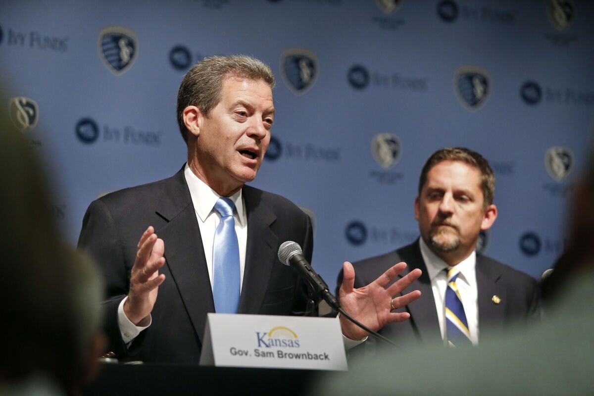 Kansas Republican Gov. Sam Brownback, left, with Kansas City Mayor Mark Holland, faces stiff competition from a Democratic challenger this year in the ruby-red state.