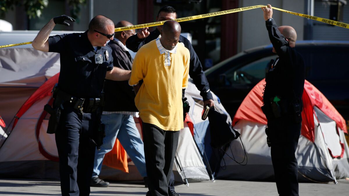 Police make an arrest during a skid row cleanup in April.