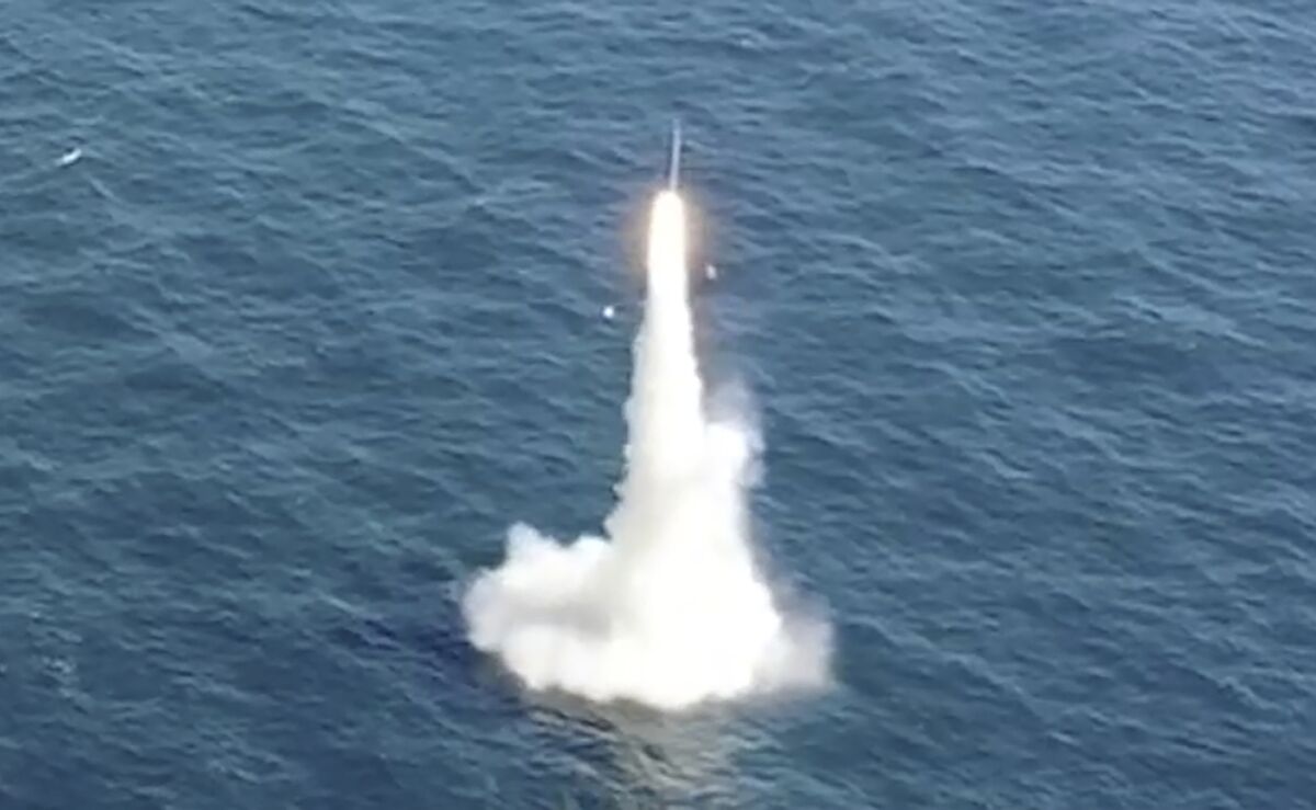 A missile flies out of the water in a sea.