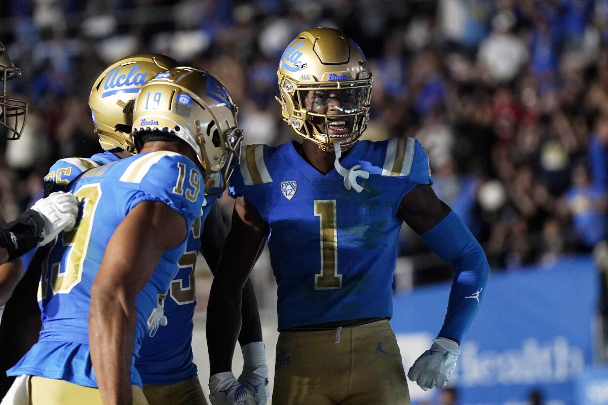 UCLA's  J.Michael Sturdivant (1) celebrates with  T.J. Harden and Kyle Ford after catching a touchdown pass.