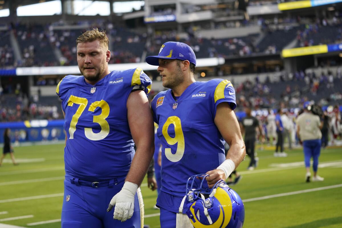 Rams offensive tackle David Edwards, left, and quarterback Matthew Stafford walk off the field.