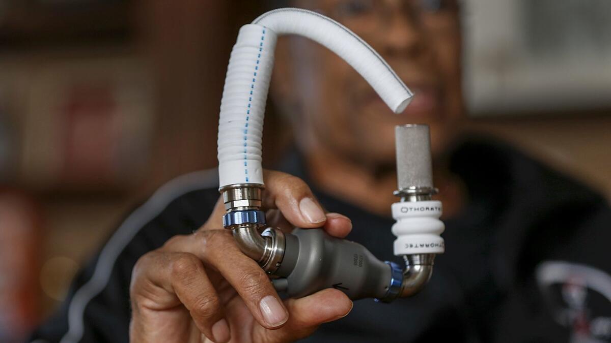 Rod Carew holds the pump device that kept him alive while waiting for a heart transplant.