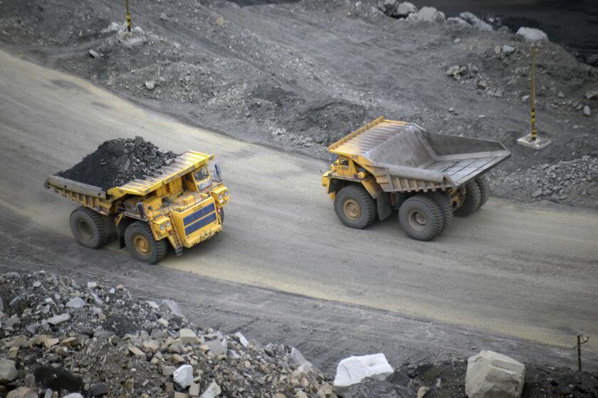 FILE - A loaded dump truck passes an empty truck as it carries away coal at the Kedrovsky open-pit coal mine in Kemerovo, Russia, Tuesday, June 16, 2015. Poland’s government has decided to block imports of coal from Russia. The move is an element in a larger strategy to reduce energy dependence on Russia which gained new urgency after the invasion of Ukraine. The government of Prime Minister Mateusz Morawiecki agreed to impose financial penalties on the private entities importing Russian coal into Poland, with Polish customs officials tasked with carrying out checks. (AP Photo/Phelan M. Ebenhack, File)