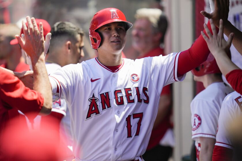 Los Angeles Angels designated hitter Shohei Ohtani (17) celebrates in the dugout with teammates.