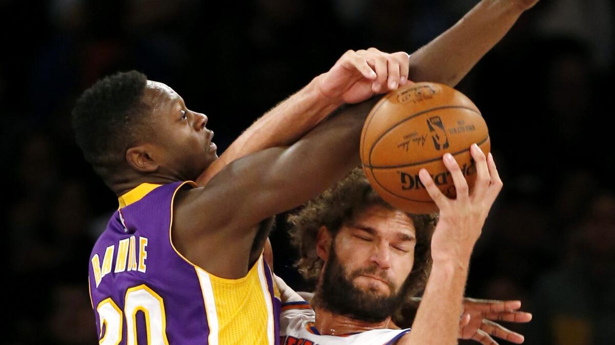 Lakers forward Julius Randle, left, gets tangled with Knicks center Robin Lopez in the second half Sunday.