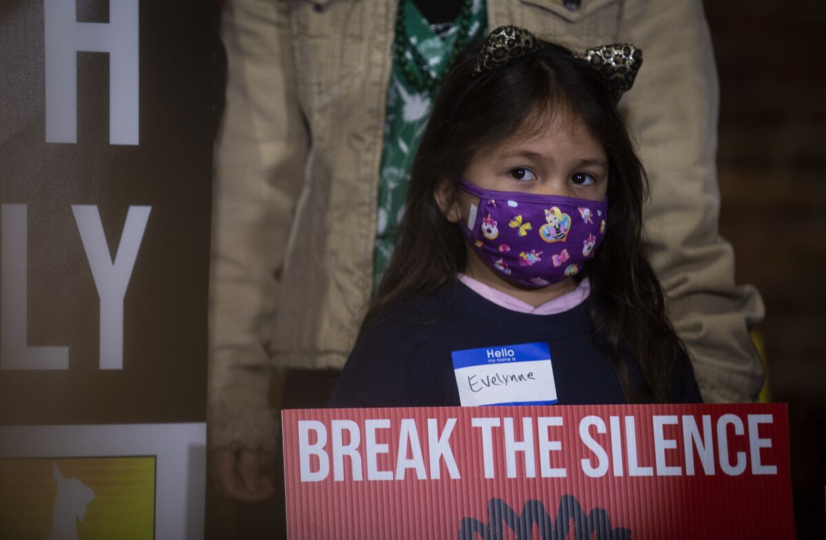 A child holds a sign at the beginning of a rally on Wednesday, March 16, 2022, in Atlanta. The Atlanta Asian Justice Rally was held on the anniversary of violence that left eight people shot and killed at various massage businesses on March 16, 2021, in the Atlanta area. Many family members and friends of the victims have been struggling with grief, trying to heal and making sure their loved ones aren't forgotten. (AP Photo/Ron Harris)