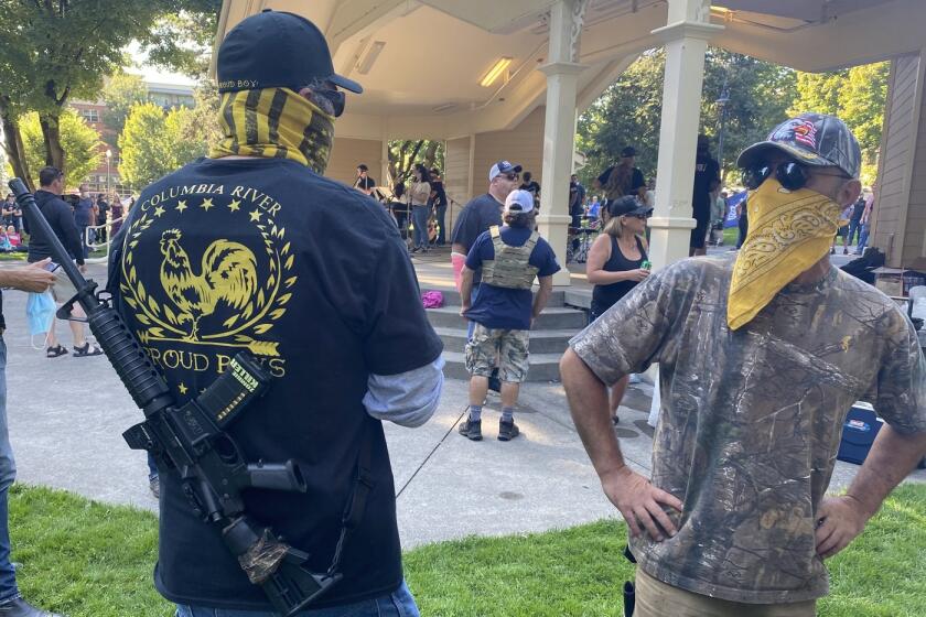 A Proud Boys member stands guard at a memorial gathering for Aaron "Jay" Danielson.