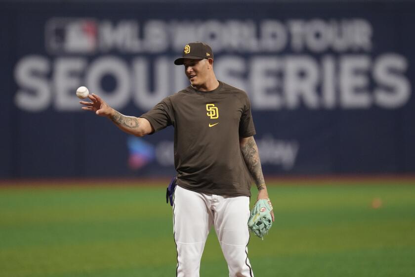 San Diego Padres third baseman Manny Machado tosses a ball into a bucket during a baseball workout at the Gocheok Sky Dome in Seoul, South Korea, Saturday, March 16, 2024. (AP Photo/Lee Jin-man)