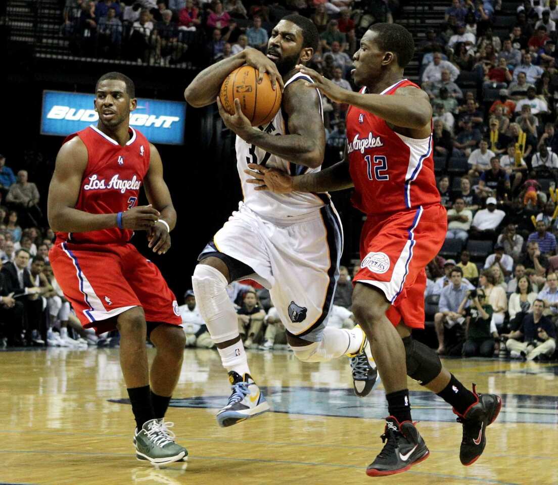 Grizzlies guard O.J. Mayo protects the ball while splitting the defense of Clippers guards Chris Paul (3) and Eric Bledsoe (12) on Monday night in Memphis.